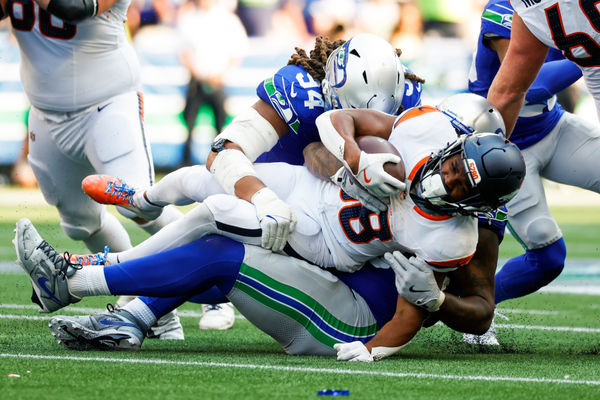 Sep 8, 2024; Seattle, Washington, USA; Denver Broncos running back Jaleel McLaughlin (38) is tackled or a loss by Seattle Seahawks defensive end Mike Morris (94) during the fourth quarter at Lumen Field. Mandatory Credit: Joe Nicholson-Imagn Images