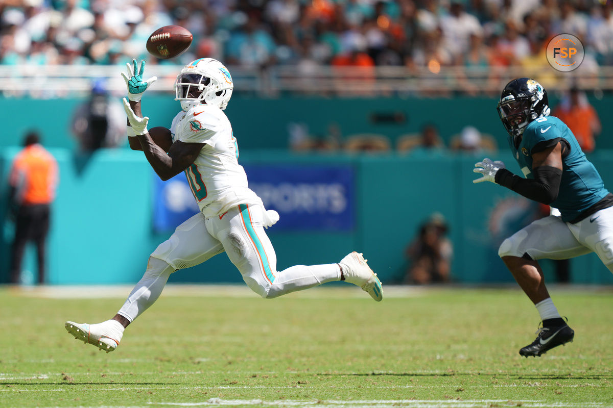 Sep 8, 2024; Miami Gardens, Florida, USA;  Miami Dolphins wide receiver Tyreek Hill (10) catches a pass for an 80-yard touchdown in the third quarter as Jacksonville Jaguars safety Andre Cisco (5) follows on the play at Hard Rock Stadium. Credit: Jim Rassol-Imagn Images