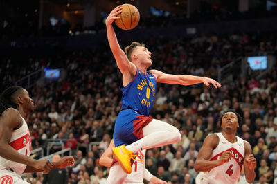 Oct 28, 2024; Toronto, Ontario, CAN; Denver Nuggets guard Christian Braun (0) goes up to dunk the ball as Toronto Raptors forward Scottie Barnes (4) looks on during the first half at Scotiabank Arena. Mandatory Credit: John E. Sokolowski-Imagn Images