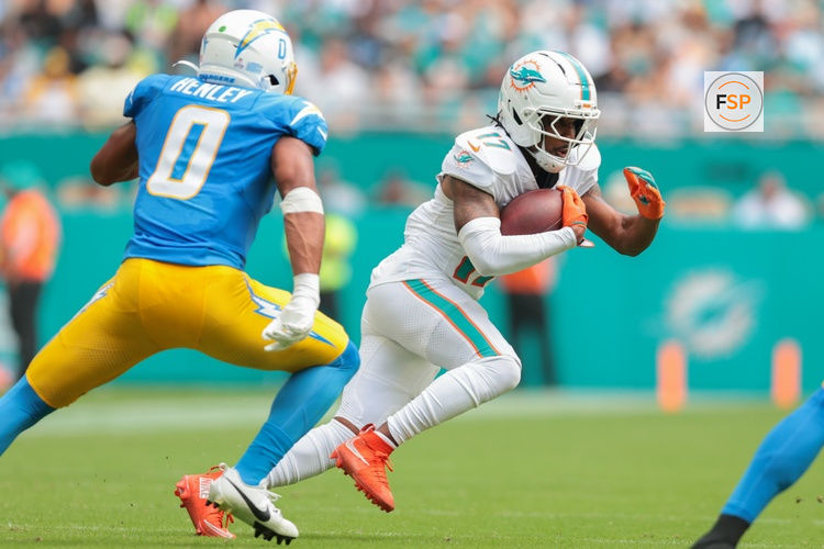 Oct 12, 2025; Miami Gardens, Florida, USA; Miami Dolphins wide receiver Jaylen Waddle (17) carries the football against Los Angeles Chargers linebacker Daiyan Henley (0) during the second quarter at Hard Rock Stadium. Credit: Sam Navarro-Imagn Images