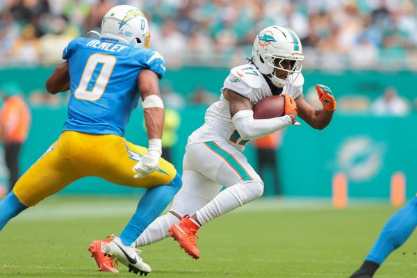 Oct 12, 2025; Miami Gardens, Florida, USA; Miami Dolphins wide receiver Jaylen Waddle (17) carries the football against Los Angeles Chargers linebacker Daiyan Henley (0) during the second quarter at Hard Rock Stadium. Mandatory Credit: Sam Navarro-Imagn Images