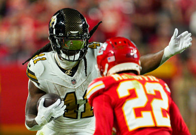 Oct 7, 2024; Kansas City, Missouri, USA; New Orleans Saints running back Alvin Kamara (41) runs the ball against Kansas City Chiefs cornerback Trent McDuffie (22) during the second half at GEHA Field at Arrowhead Stadium. Mandatory Credit: Jay Biggerstaff-Imagn Images