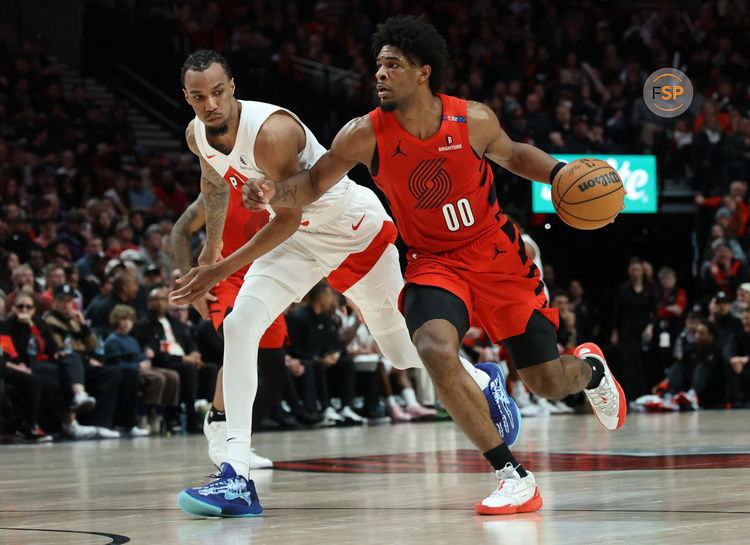 Mar 16, 2025; Portland, Oregon, USA;  Portland Trail Blazers guard Scoot Henderson (00) dribbles the ball past Toronto Raptors guard A.J. Lawson (0) in the second half at Moda Center. Credit: Jaime Valdez-Imagn Images