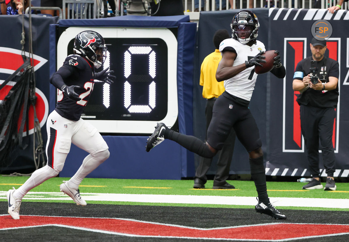 Sep 29, 2024; Houston, Texas, USA;  Jacksonville Jaguars wide receiver Brian Thomas Jr. (7) catches a touchdown against Houston Texans safety Eric Murray (23) in the first quarterat NRG Stadium. Credit: Thomas Shea-Imagn Images