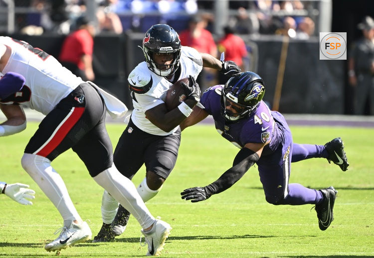Oct 5, 2025; Baltimore, Maryland, USA; Houston Texans running back Woody Marks (27) runs for a gain past Baltimore Ravens linebacker Teddye Buchanan (40) during the second quarter at M&T Bank Stadium. Credit: Rafael Suanes-Imagn Images