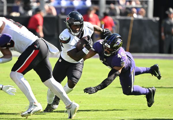 Oct 5, 2025; Baltimore, Maryland, USA; Houston Texans running back Woody Marks (27) runs for a gain past Baltimore Ravens linebacker Teddye Buchanan (40) during the second quarter at M&T Bank Stadium. Mandatory Credit: Rafael Suanes-Imagn Images