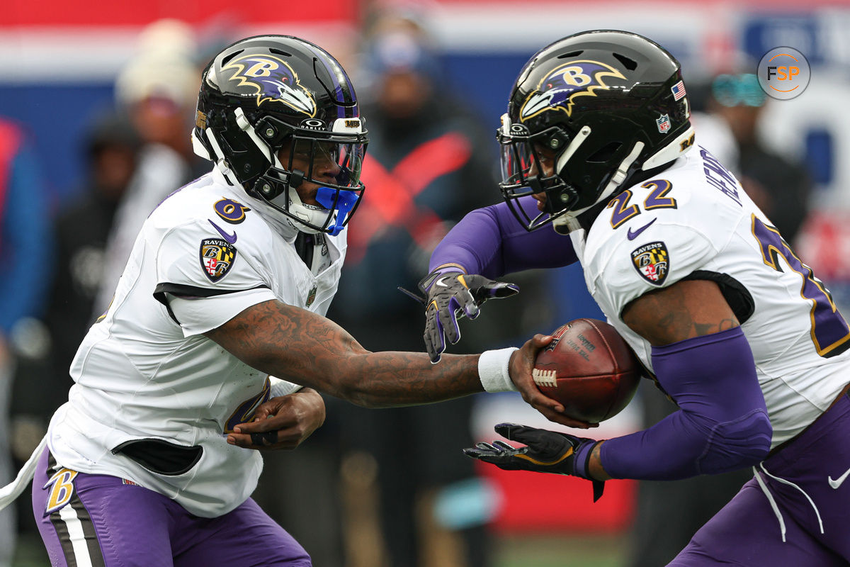 Dec 15, 2024; East Rutherford, New Jersey, USA; Baltimore Ravens quarterback Lamar Jackson (8) hands off to running back Derrick Henry (22) during the first quarter at MetLife Stadium. Credit: Vincent Carchietta-Imagn Images