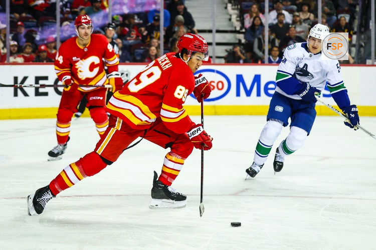 Oct 1, 2025; Calgary, Alberta, CAN; Calgary Flames defenseman Zayne Parekh (89) skates with the puck against the Vancouver Canucks during the third period at Scotiabank Saddledome. Credit: Sergei Belski-Imagn Images