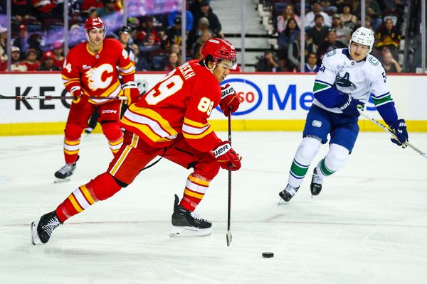Oct 1, 2025; Calgary, Alberta, CAN; Calgary Flames defenseman Zayne Parekh (89) skates with the puck against the Vancouver Canucks during the third period at Scotiabank Saddledome. Mandatory Credit: Sergei Belski-Imagn Images