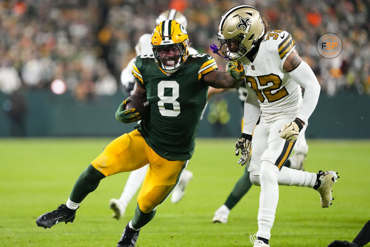 Dec 23, 2024; Green Bay, Wisconsin, USA;  Green Bay Packers running back Josh Jacobs (8) stiff arms New Orleans Saints safety Tyrann Mathieu (32) during the first quarter  at Lambeau Field. Credit: Jeff Hanisch-Imagn Images