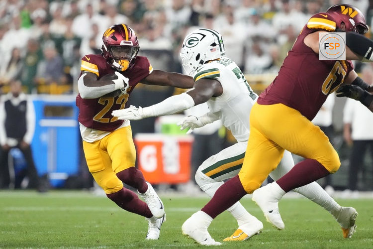 Sep 11, 2025; Green Bay, Wisconsin, USA; Washington Commanders running back Jacory Croskey-Merritt (22) runs against Green Bay Packers linebacker Quay Walker (7) in the third quarter at Lambeau Field. Credit: Jeff Hanisch-Imagn Images