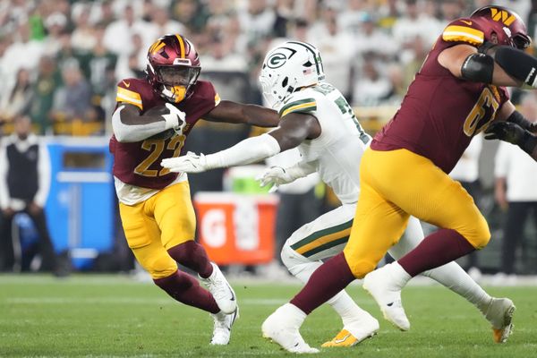 Sep 11, 2025; Green Bay, Wisconsin, USA; Washington Commanders running back Jacory Croskey-Merritt (22) runs against Green Bay Packers linebacker Quay Walker (7) in the third quarter at Lambeau Field. Mandatory Credit: Jeff Hanisch-Imagn Images