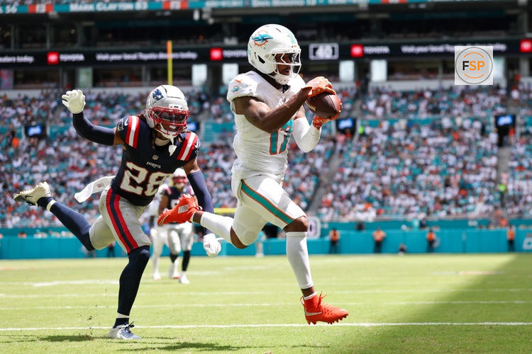 Sep 14, 2025; Miami Gardens, Florida, USA; Miami Dolphins wide receiver Jaylen Waddle (17) catches a pass for a touchdown defended by New England Patriots cornerback Alex Austin (28) in the second quarter  at Hard Rock Stadium. Credit: Nathan Ray Seebeck-Imagn Images