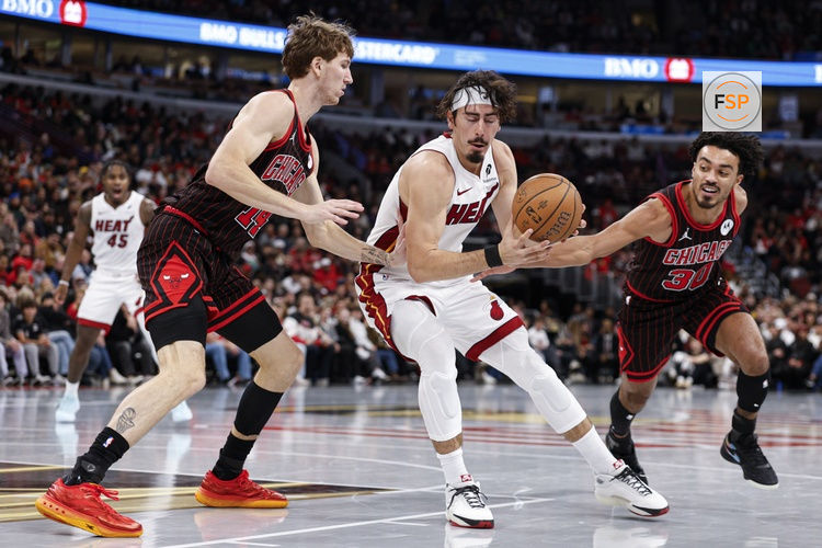 Nov 21, 2025; Chicago, Illinois, USA; Chicago Bulls forward Matas Buzelis (14) and guard Tre Jones (30) defend against Miami Heat forward Jaime Jaquez Jr. (11) during the second half at United Center. Credit: Kamil Krzaczynski-Imagn Images