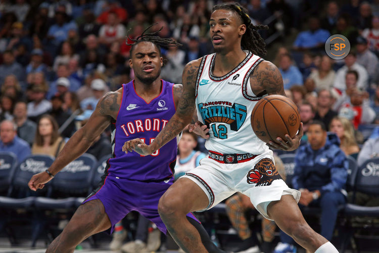 Dec 26, 2024; Memphis, Tennessee, USA; Memphis Grizzlies guard Ja Morant (12) handles the ball as Toronto Raptors guard Davion Mitchell (45) defends during the first half at FedExForum. Credit: Petre Thomas-Imagn Images