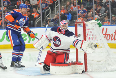 Dec 31, 2018; Edmonton, Alberta, CAN; Edmonton Oilers left winger Milan Lucic (27) looks on as Winnipeg Jets goalie Connor Hellebuck (37) makes a save during the second period at Rogers Place.  Mandatory Credit: Walter Tychnowicz-USA TODAY Sports