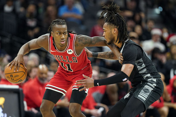 Dec 5, 2024; San Antonio, Texas, USA; Chicago Bulls guard Ayo Dosunmu (11) looks to pass the ball while defended by guard Stephon Castle (5) during the second half at Frost Bank Center. Mandatory Credit: Scott Wachter-Imagn Images