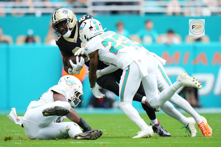Nov 30, 2025; Miami Gardens, Florida, USA; New Orleans Saints tight end Juwan Johnson (83) is tackled by Miami Dolphins cornerback Jack Jones (23) during the first half at Hard Rock Stadium. Credit: Rich Storry-Imagn Images