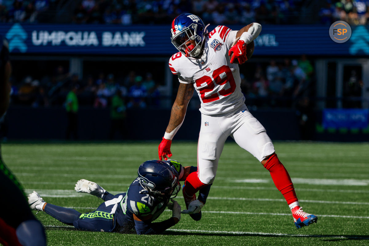 Oct 6, 2024; Seattle, Washington, USA; New York Giants running back Tyrone Tracy Jr. (29) breaks a tackle attempt by Seattle Seahawks safety Julian Love (20) during the second quarter at Lumen Field. Credit: Joe Nicholson-Imagn Images