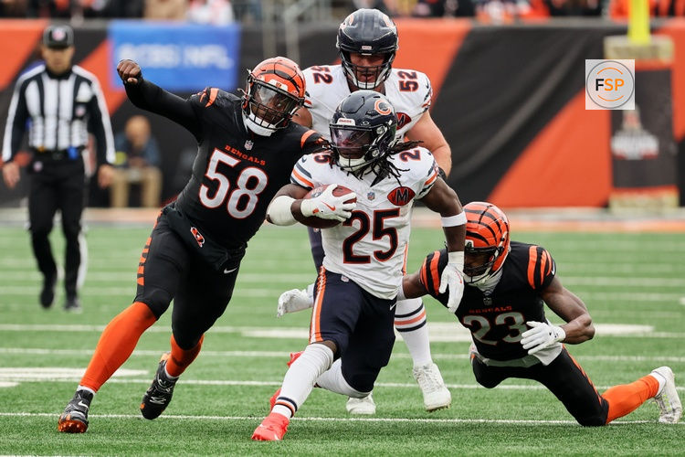 Nov 2, 2025; Cincinnati, Ohio, USA; Chicago Bears running back Kyle Monangai (25) runs the ball against Cincinnati Bengals defensive end Joseph Ossai (58) and cornerback Dax Hill (23) during the third quarter at Paycor Stadium. Credit: Joseph Maiorana-Imagn Images