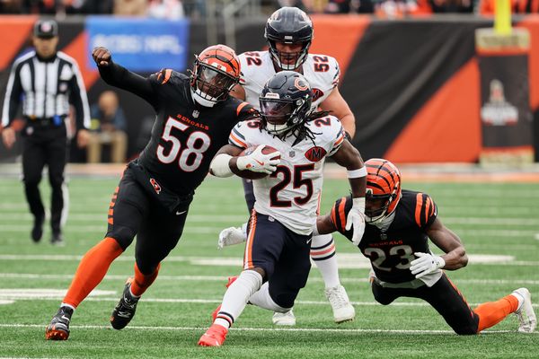Nov 2, 2025; Cincinnati, Ohio, USA; Chicago Bears running back Kyle Monangai (25) runs the ball against Cincinnati Bengals defensive end Joseph Ossai (58) and cornerback Dax Hill (23) during the third quarter at Paycor Stadium. Mandatory Credit: Joseph Maiorana-Imagn Images