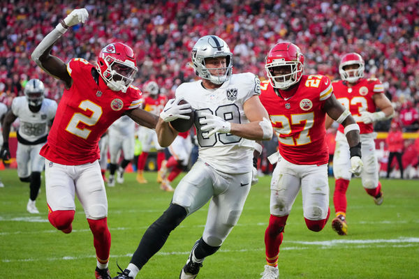 Nov 29, 2024; Kansas City, Missouri, USA; Las Vegas Raiders tight end Brock Bowers (89) scores a touchdown as Kansas City Chiefs cornerback Joshua Williams (2) and safety Chamarri Conner (27) chase during the second half at GEHA Field at Arrowhead Stadium. Mandatory Credit: Denny Medley-Imagn Images