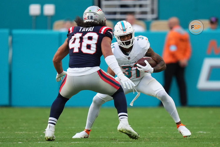 Nov 24, 2024; Miami Gardens, Florida, USA; Miami Dolphins running back Raheem Mostert (31) runs the ball around New England Patriots linebacker Jahlani Tavai (48) during the second half at Hard Rock Stadium. Credit: Jasen Vinlove-Imagn Images