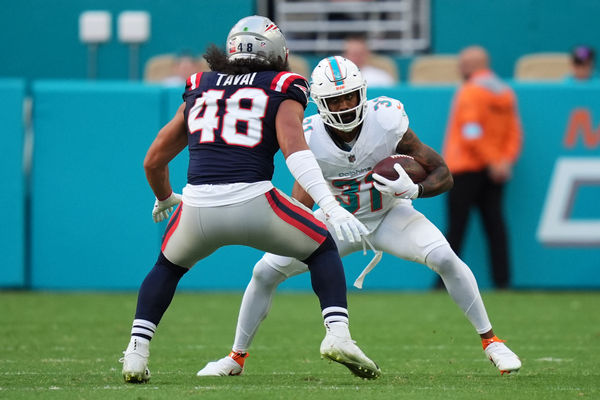 Nov 24, 2024; Miami Gardens, Florida, USA; Miami Dolphins running back Raheem Mostert (31) runs the ball around New England Patriots linebacker Jahlani Tavai (48) during the second half at Hard Rock Stadium. Mandatory Credit: Jasen Vinlove-Imagn Images