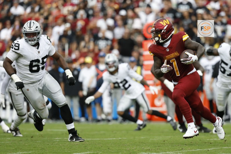Sep 21, 2025; Landover, Maryland, USA; Washington Commanders wide receiver Deebo Samuel Sr. (1) runs with the ball as Las Vegas Raiders defensive tackle Adam Butler (69) chases during the third quarter at Northwest Stadium. Credit: Geoff Burke-Imagn Images