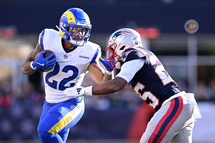 Nov 17, 2024; Foxborough, Massachusetts, USA; Los Angeles Rams running back Blake Corum (22) runs with the ball against New England Patriots cornerback Marcus Jones (25) during the first half at Gillette Stadium. Credit: Brian Fluharty-Imagn Images