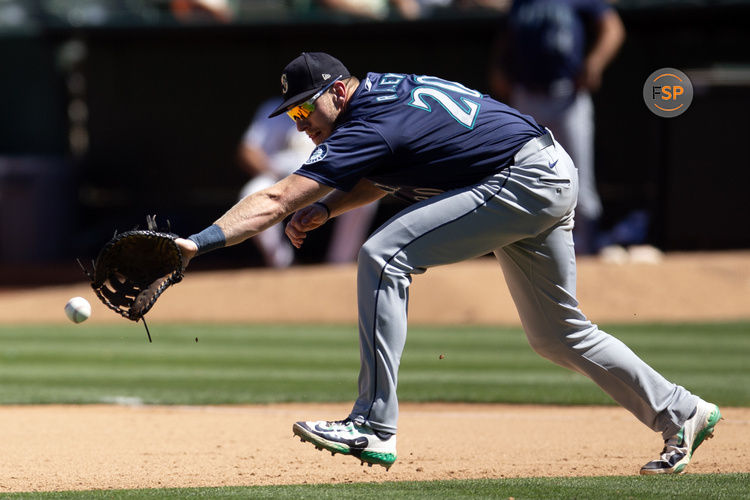 Sep 5, 2024; Oakland, California, USA; Seattle Mariners first baseman Luke Raley (20) attempts to field a ball hit by Oakland Athletics right fielder Lawrence Butler (not pictured) during the seventh inning at Oakland-Alameda County Coliseum. Credit: D. Ross Cameron-Imagn Images