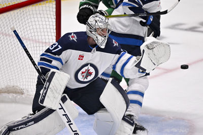 May 17, 2025; Dallas, Texas, USA; Winnipeg Jets goaltender Connor Hellebuyck (37) makes a glove save on a Dallas Stars shot during the third period in game six of the second round of the 2025 Stanley Cup Playoffs at American Airlines Center. Mandatory Credit: Jerome Miron-Imagn Images