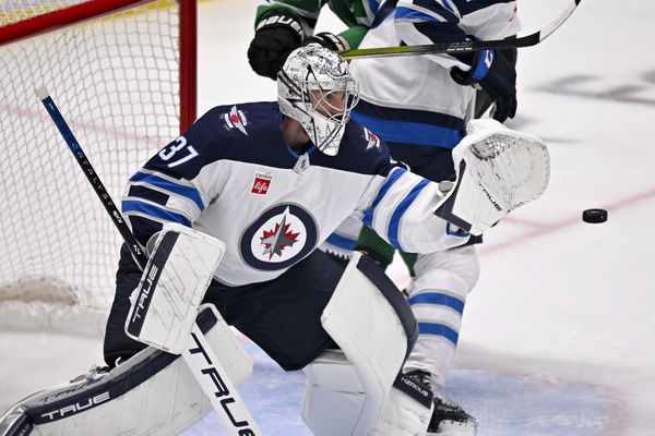 May 17, 2025; Dallas, Texas, USA; Winnipeg Jets goaltender Connor Hellebuyck (37) makes a glove save on a Dallas Stars shot during the third period in game six of the second round of the 2025 Stanley Cup Playoffs at American Airlines Center. Mandatory Credit: Jerome Miron-Imagn Images