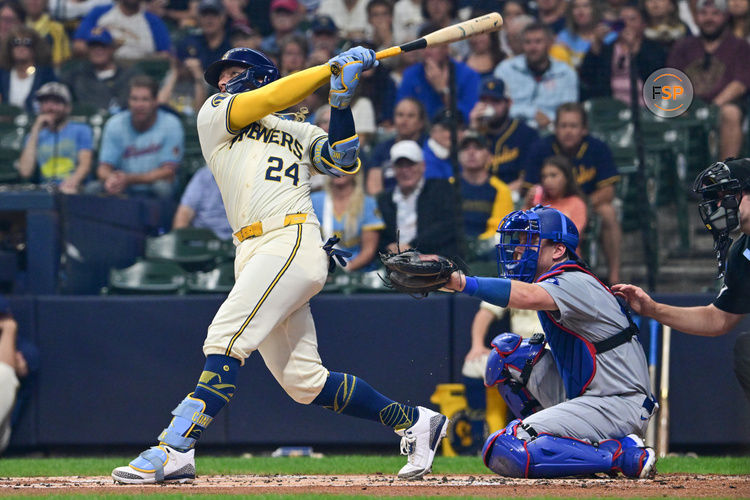 Aug 15, 2024; Milwaukee, Wisconsin, USA;  Milwaukee Brewers catcher William Contreras (24) hits a solo home run in the first inning as Los Angeles Dodgers catcher Will Smith (16) looks on at American Family Field. Credit: Benny Sieu-USA TODAY Sports