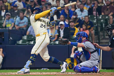 Aug 15, 2024; Milwaukee, Wisconsin, USA;  Milwaukee Brewers catcher William Contreras (24) hits a solo home run in the first inning as Los Angeles Dodgers catcher Will Smith (16) looks on at American Family Field. Mandatory Credit: Benny Sieu-USA TODAY Sports