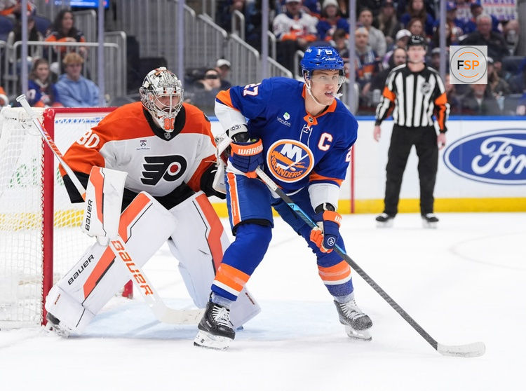 Apr 3, 2026; Elmont, New York, USA; Philadelphia Flyers goaltender Dan Vladar (80) and New York Islanders forward Anders Lee (27) wait for the puck during the second period at UBS Arena. Credit: Alexander Wohl-Imagn Images