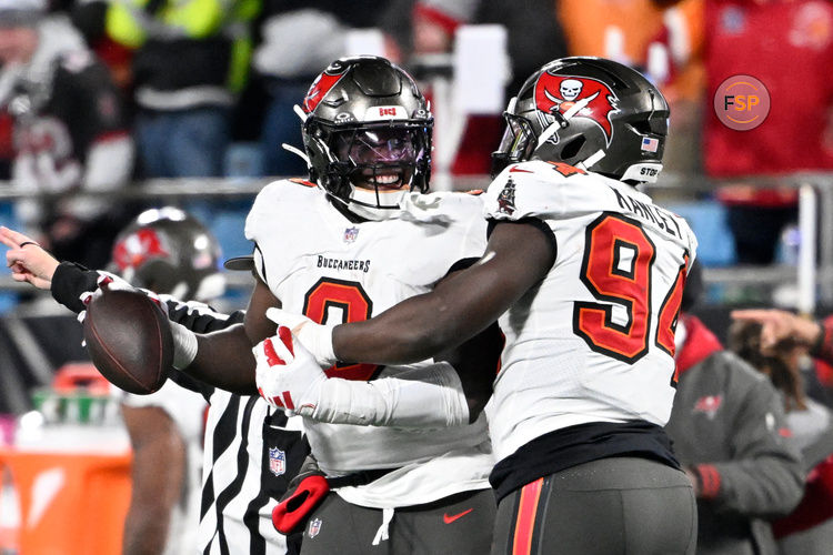 Dec 1, 2024; Charlotte, North Carolina, USA; Tampa Bay Buccaneers linebacker Yaya Diaby (0) celebrates with defensive tackle Calijah Kancey (94) after recovering a fumble in overtime in overtime at Bank of America Stadium. Credit: Bob Donnan-Imagn Images