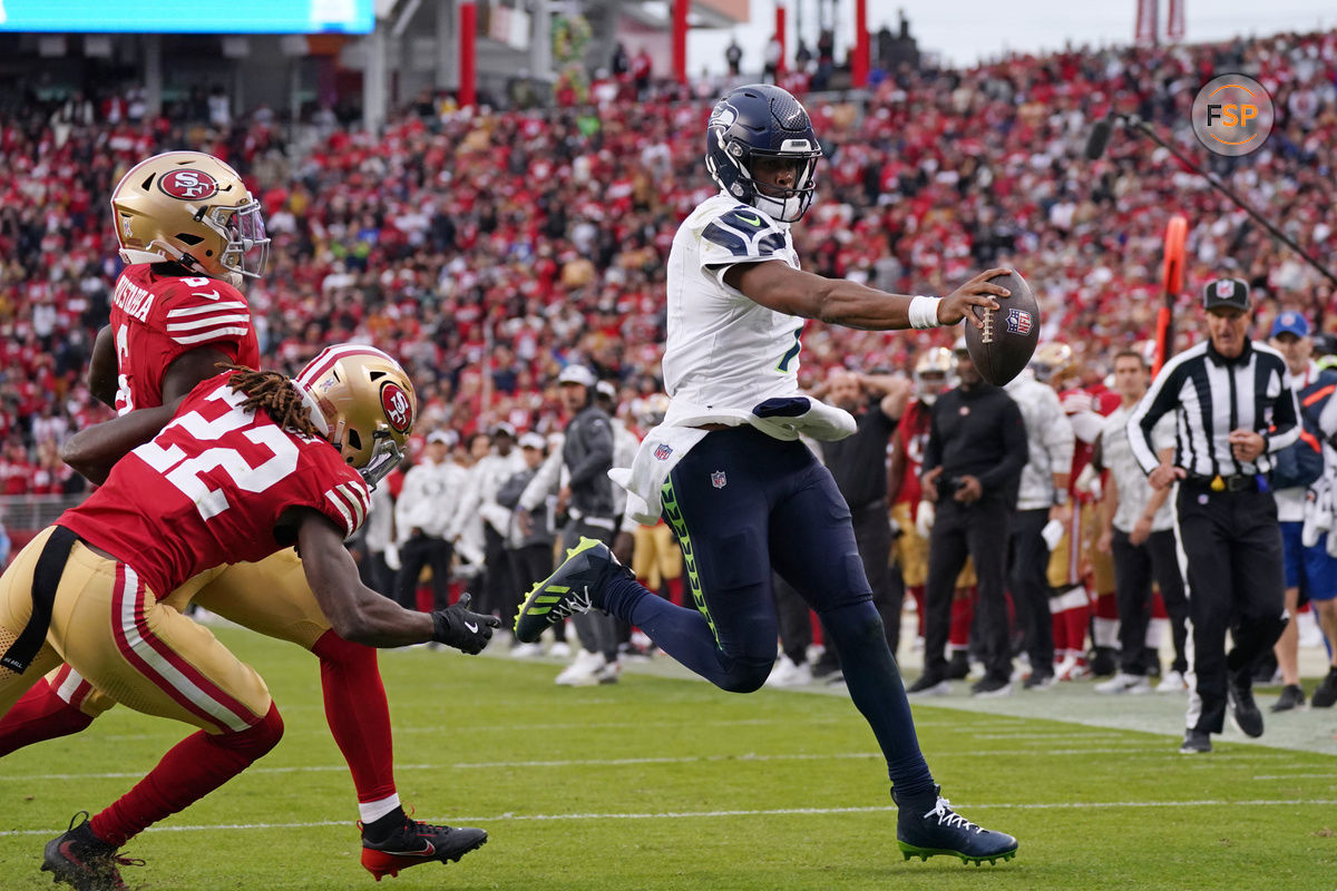 Nov 17, 2024; Santa Clara, California, USA; Seattle Seahawks quarterback Geno Smith (7) scores a rushing touchdown past San Francisco 49ers cornerback Isaac Yiadom (22) to win the game in the fourth quarter at Levi's Stadium. Credit: David Gonzales-Imagn Images