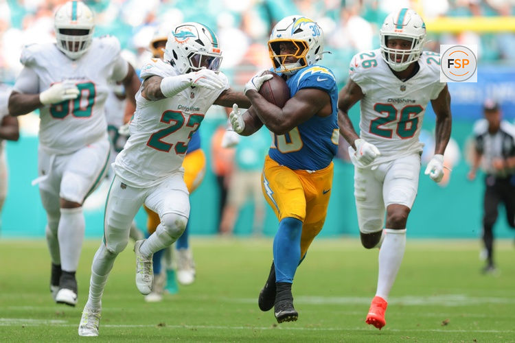 Oct 12, 2025; Miami Gardens, Florida, USA; Los Angeles Chargers running back Kimani Vidal (30) carries the football against Miami Dolphins cornerback Jack Jones (23) during the third quarter at Hard Rock Stadium. Credit: Sam Navarro-Imagn Images