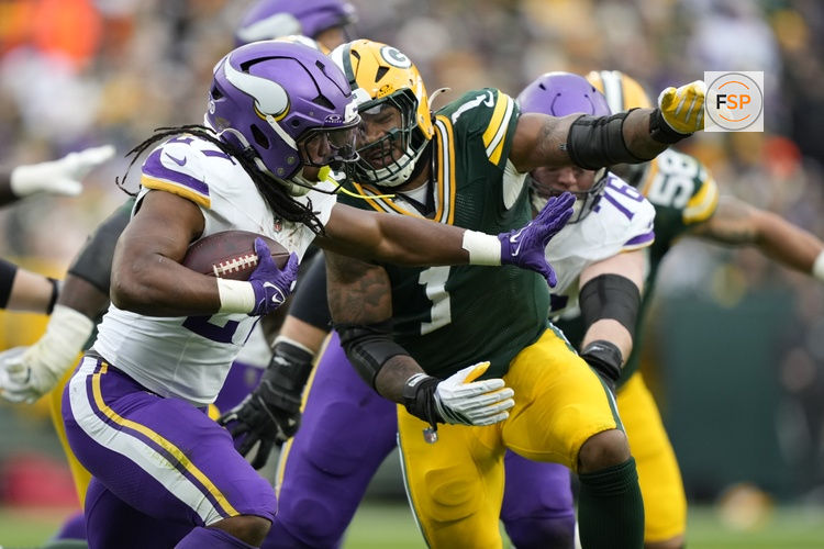 Nov 23, 2025; Green Bay, Wisconsin, USA; Minnesota Vikings running back Jordan Mason (27) carries the ball as Green Bay Packers defensive end Micah Parsons (1) defends during the second half at Lambeau Field. Credit: Kayla Wolf-Imagn Images