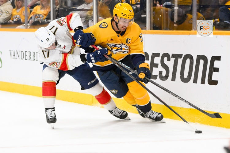 Feb 25, 2025; Nashville, Tennessee, USA;  Nashville Predators defenseman Roman Josi (59) and Florida Panthers center Evan Rodrigues (17) battle for the puck during the second period at Bridgestone Arena. Credit: Steve Roberts-Imagn Images