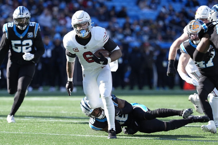 Dec 22, 2024; Charlotte, North Carolina, USA; Arizona Cardinals running back James Conner (6) tries to break free from Carolina Panthers safety Demani Richardson (36) during the second quarter at Bank of America Stadium. Credit: Jim Dedmon-Imagn Images