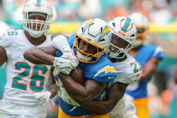 Oct 12, 2025; Miami Gardens, Florida, USA; Los Angeles Chargers running back Kimani Vidal (30) carries the football against Miami Dolphins cornerback Jack Jones (23) during the third quarter at Hard Rock Stadium. Mandatory Credit: Sam Navarro-Imagn Images