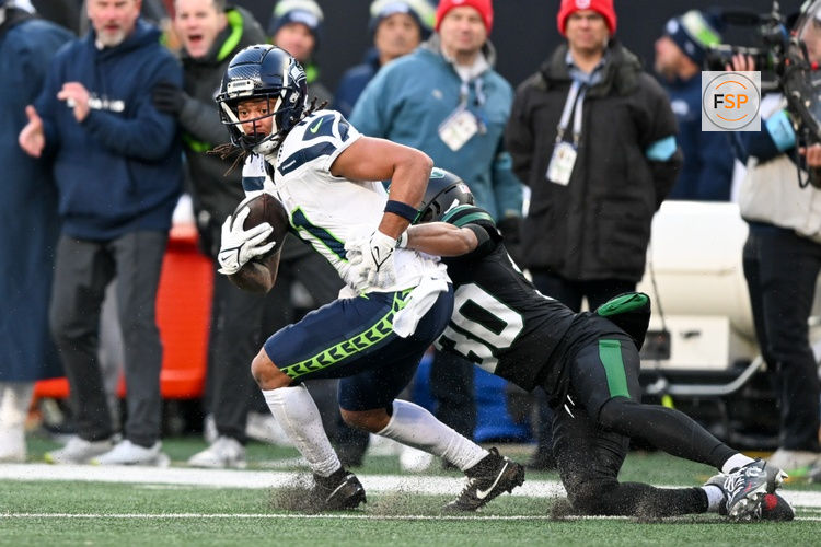 Dec 1, 2024; East Rutherford, New Jersey, USA; Seattle Seahawks wide receiver Jaxon Smith-Njigba (11) runs with the ball after a catch and is tackled by New York Jets cornerback Michael Carter II (30) during the third quarter at MetLife Stadium. Credit: Mark Smith-Imagn Images