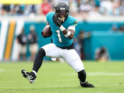 Oct 6, 2024; Jacksonville, Florida, USA; Jacksonville Jaguars running back Travis Etienne Jr. (1) runs with the ball against the Indianapolis Colts in the first quarter at EverBank Stadium. Mandatory Credit: Nathan Ray Seebeck-Imagn Images