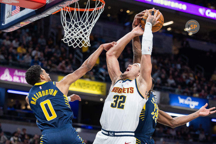 Feb 24, 2025; Indianapolis, Indiana, USA; Denver Nuggets forward Aaron Gordon (32) shoots the ball while Indiana Pacers guard Tyrese Haliburton (0) and forward Aaron Nesmith (23) defend in the second half at Gainbridge Fieldhouse. Credit: Trevor Ruszkowski-Imagn Images