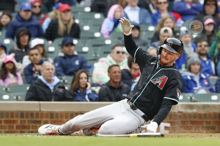 Apr 20, 2025; Chicago, Illinois, USA; Arizona Diamondbacks first baseman Pavin Smith (26) scores against the Chicago Cubs during the fourth inning at Wrigley Field. Credit: Kamil Krzaczynski-Imagn Images