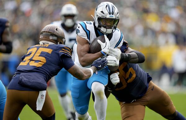 Nov 2, 2025; Green Bay, Wisconsin, USA; Carolina Panthers running back Chuba Hubbard (30) runs against Green Bay Packers cornerback Keisean Nixon (25) during the second half at Lambeau Field. Mandatory Credit: Jeff Hanisch-Imagn Images