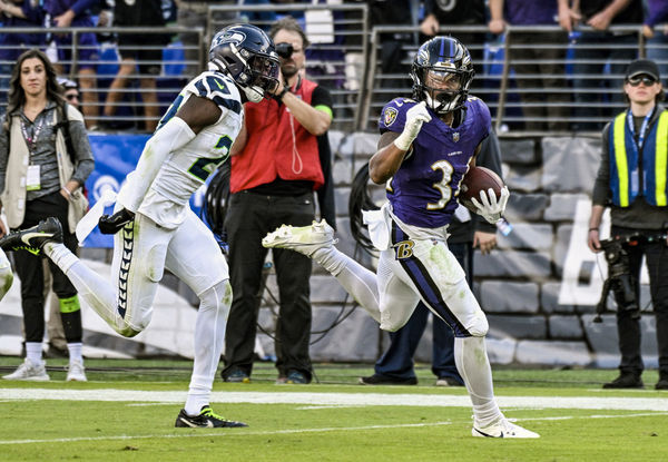 BALTIMORE, MD - NOVEMBER 05:  Baltimore Ravens running back Keaton Mitchell (34) runs for a touchdown  against Seattle Seahawks cornerback Riq Woolen (27) during the Seattle Seahawks game versus the Baltimore Ravens on November 5, 2023 at M&T Bank Stadium in Baltimore, MD.  (Photo by Mark Goldman/Icon Sportswire)