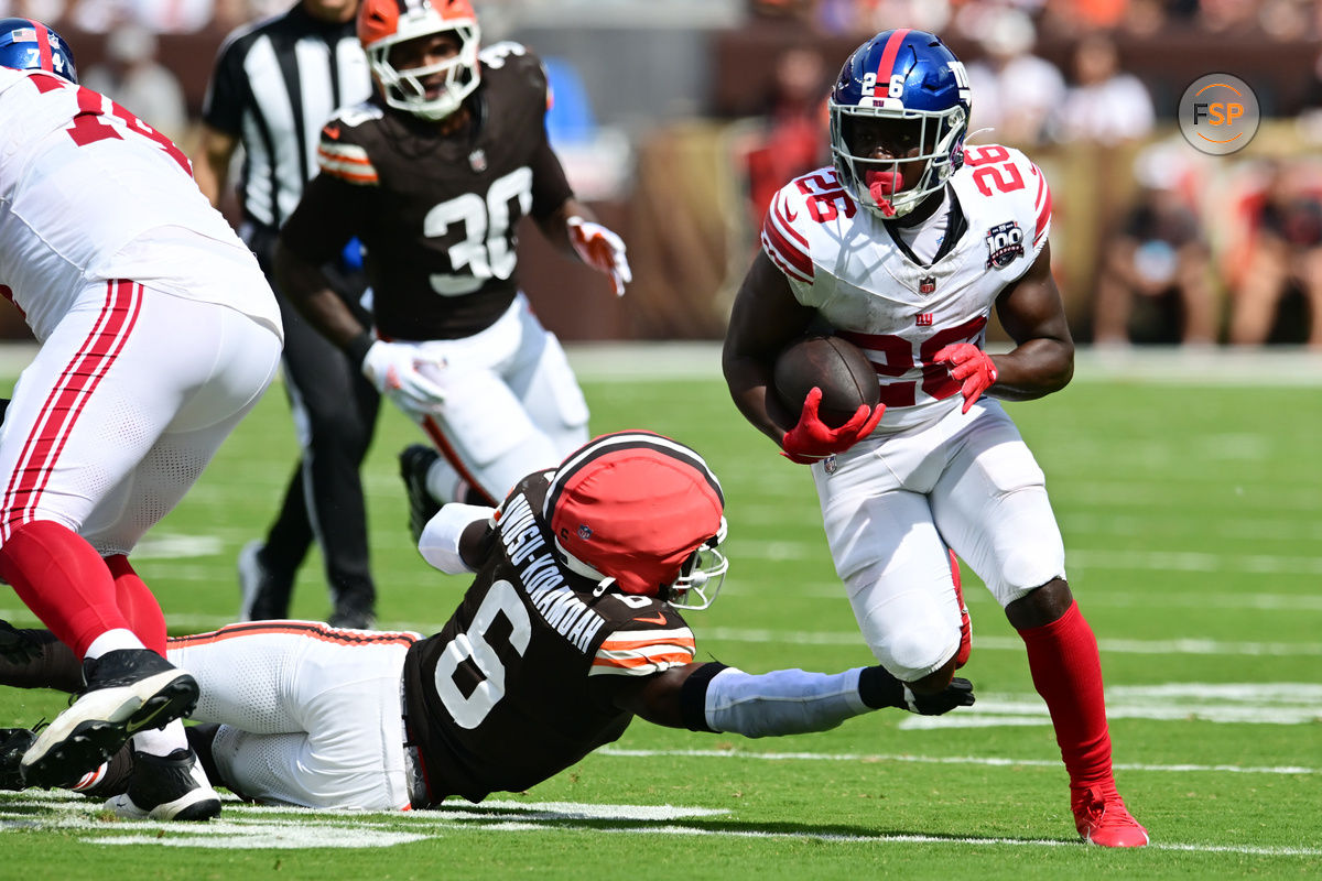 Sep 22, 2024; Cleveland, Ohio, USA; New York Giants running back Devin Singletary (26) runs with the ball as Cleveland Browns linebacker Jeremiah Owusu-Koramoah (6) goes for the tackle during the first quarter at Huntington Bank Field. Credit: Ken Blaze-Imagn Images